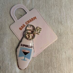 Anthropologie bag charm. Small tag stamped “travel”.